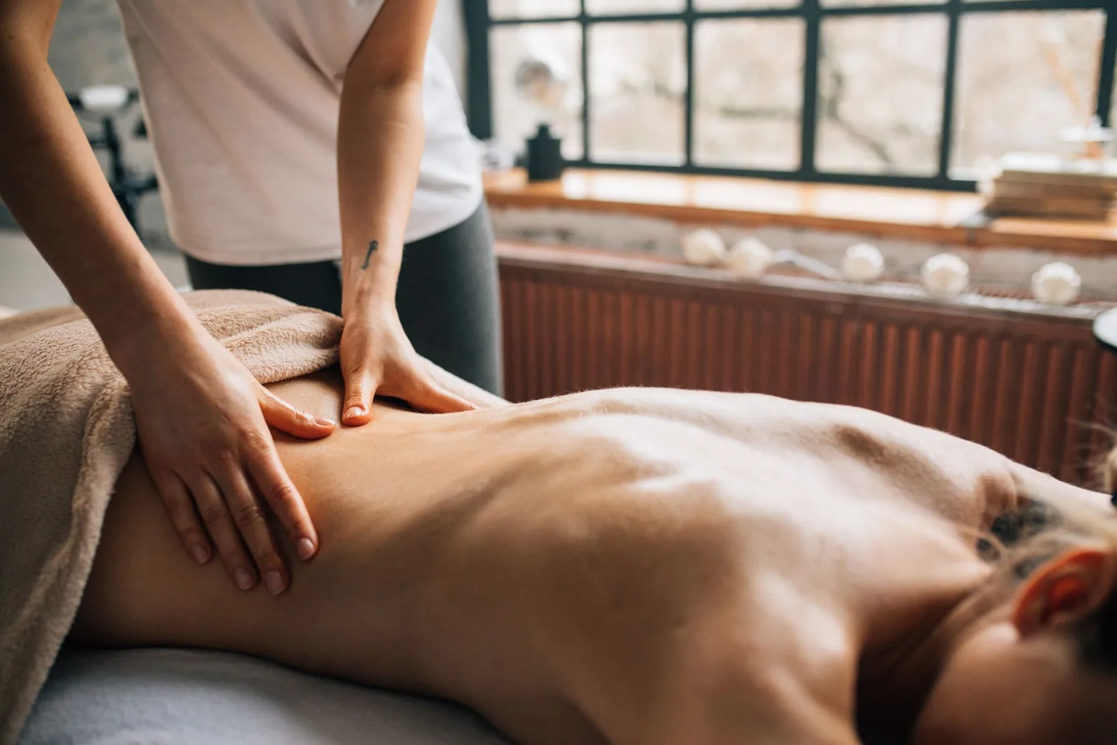 Séance de massage Deep tissue : pressions lentes le long du dos, en cabinet